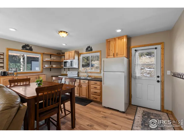 a kitchen with refrigerator and chairs