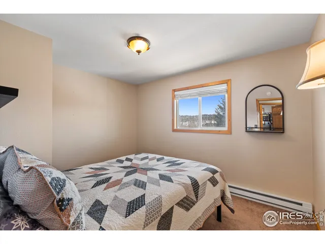 a bedroom with a bed and painting on the wall