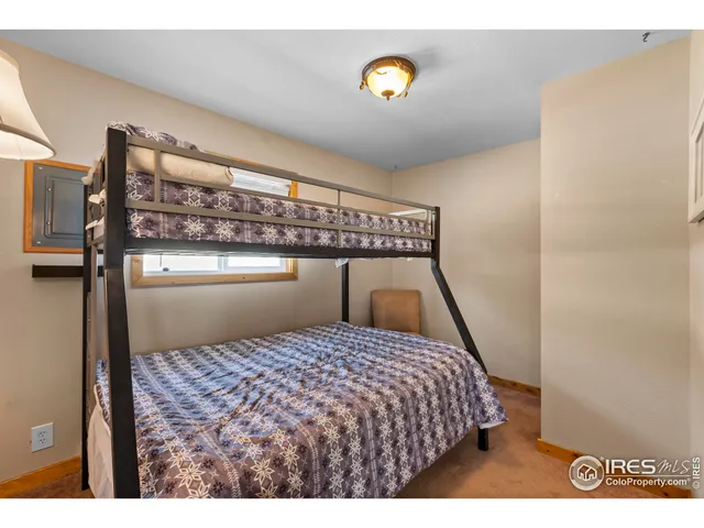 a bedroom with a bed and painting on the wall