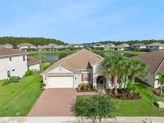 an aerial view of a house with a yard and lake view