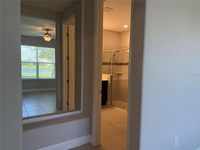 an empty room with a window and a fan