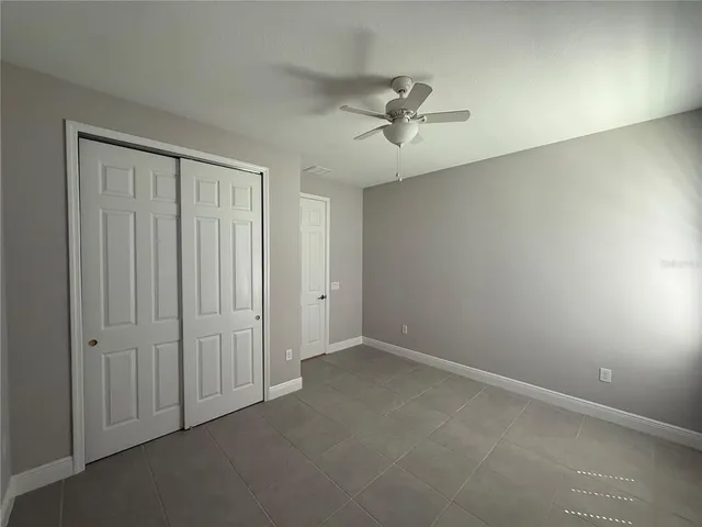 a view of a room with a chandelier fan and windows