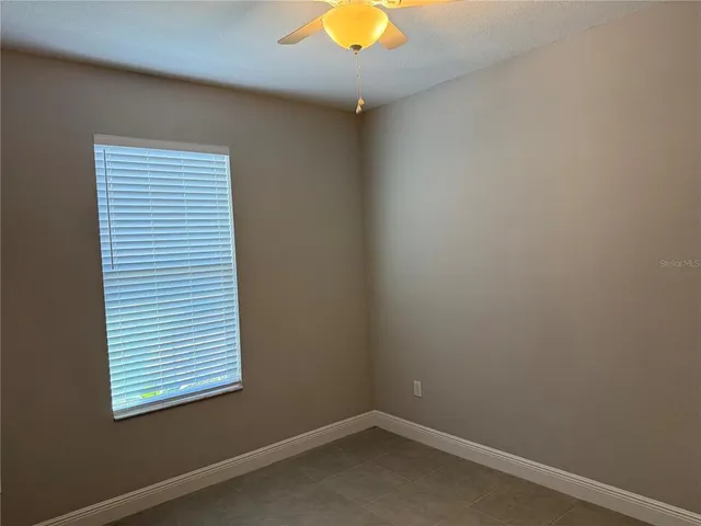 a view of an empty room with a ceiling fan