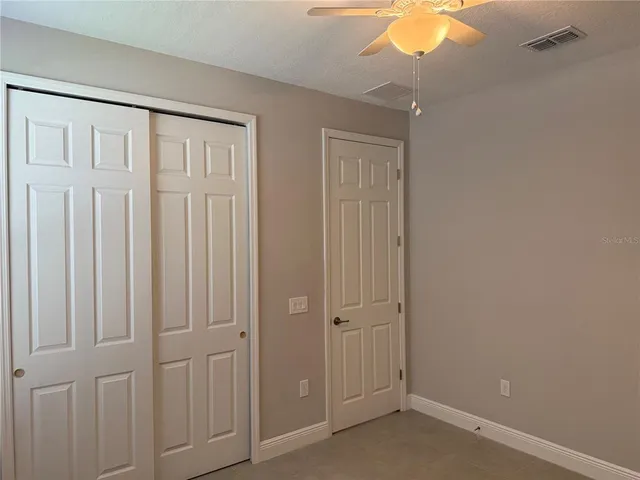 an empty room with a window and a fan