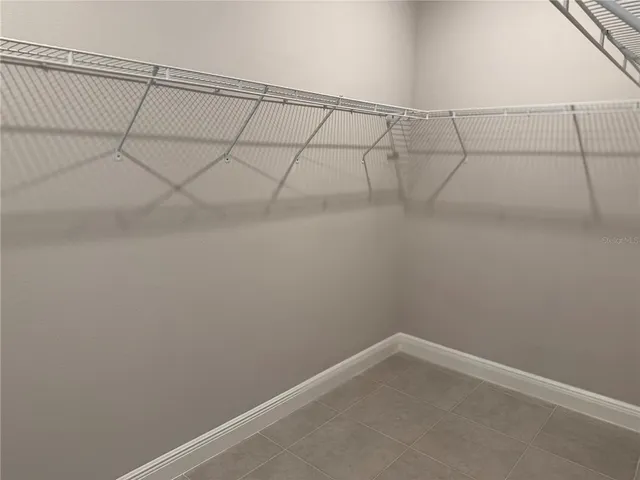 a view of an empty room with wooden floor and large windows with ocean view
