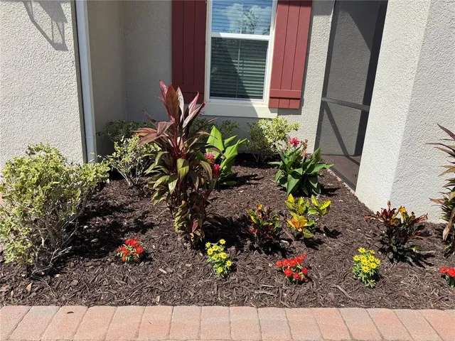 a view of a swimming pool with chairs and table in a backyard