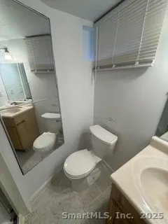a white toilet sitting next to a bathroom sink and vanity