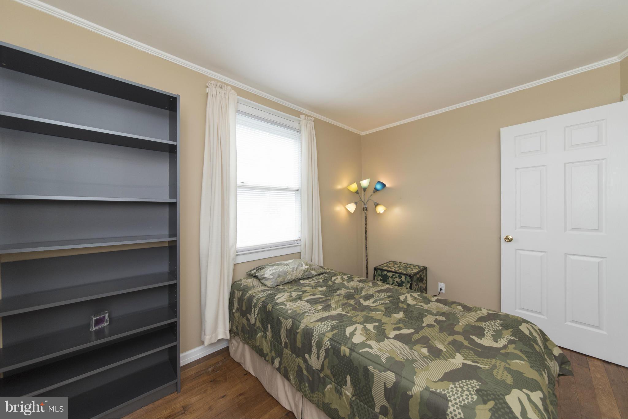 3117 Cornwall Road Baltimore, MD 21222 - Photo 15 of 30 a bedroom with a bed and a lamp on dresser