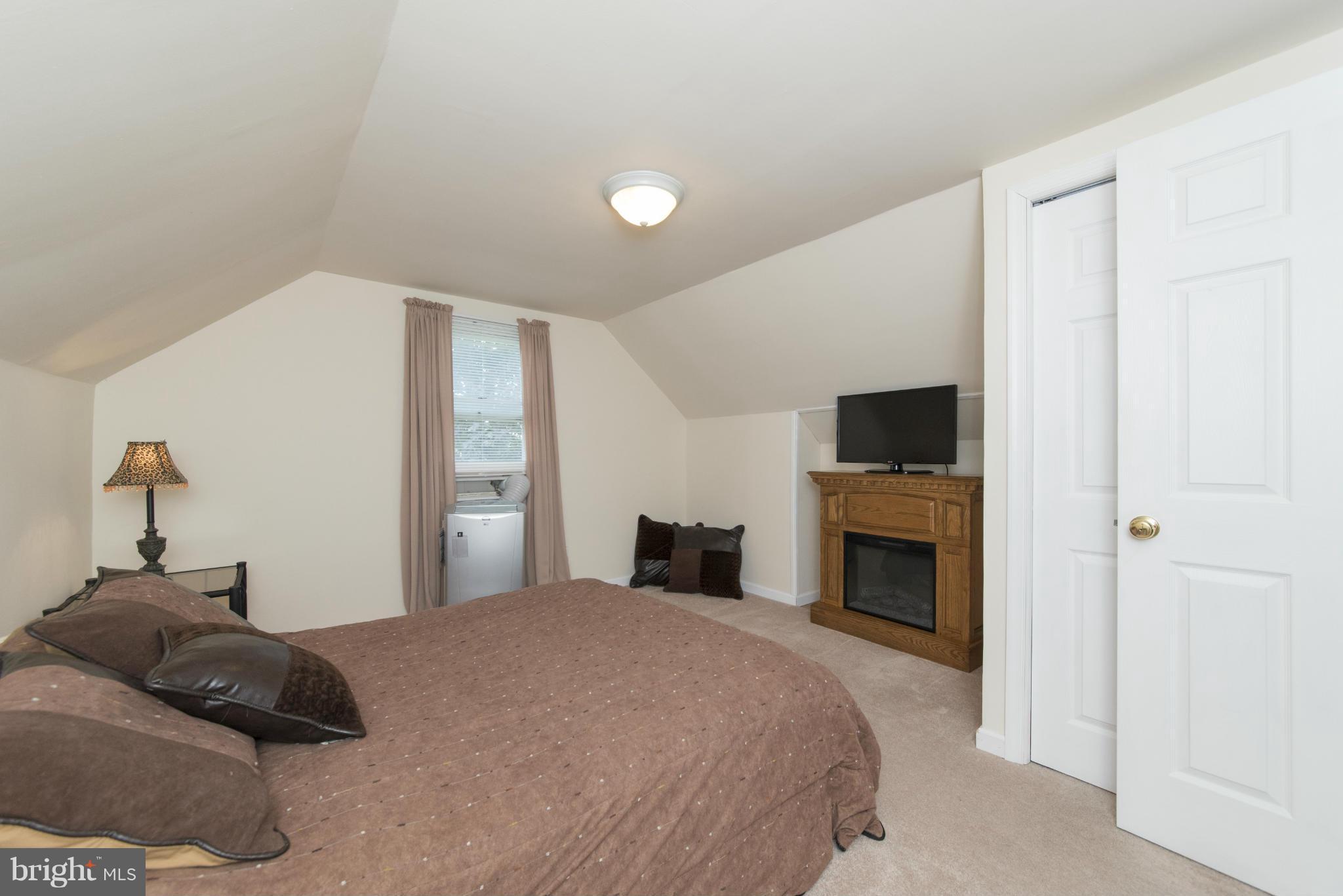 3117 Cornwall Road Baltimore, MD 21222 - Photo 22 of 30 a bedroom with a large bed and a fireplace