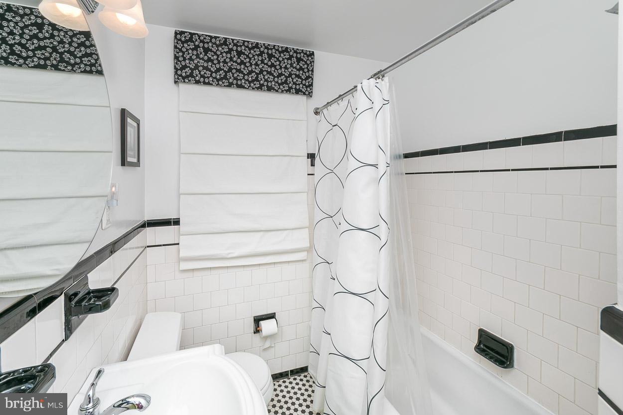 6714 Sherwood Road Baltimore, MD 21239 - Photo 22 of 30 a bathroom with a shower curtain and a sink