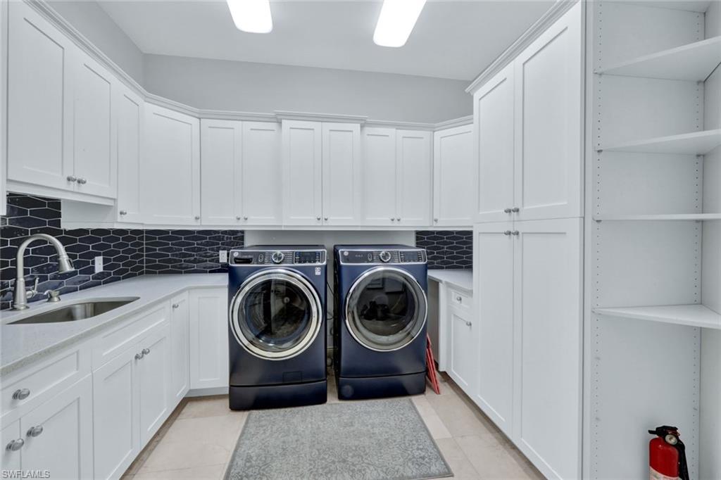 253 Cheshire Way Naples, FL 34110 - Photo 38 of 50 Washroom with washing machine and dryer, light tile patterned floors, and cabinet space
