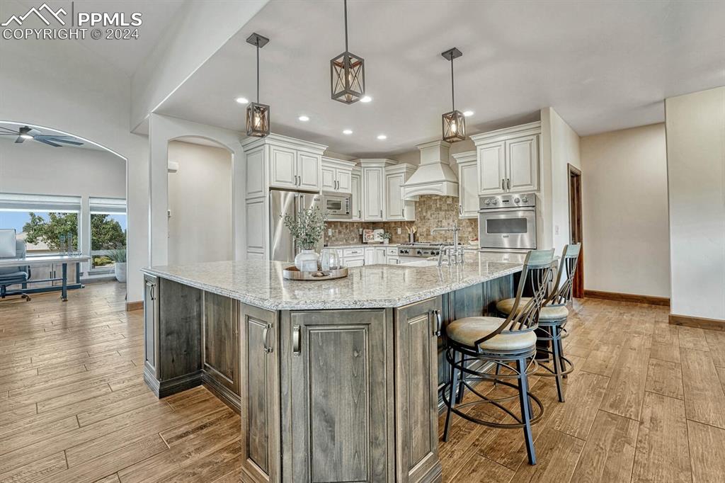 19210 Royal Troon Drive Monument, CO 80132 - Photo 11 of 50 a kitchen with stainless steel appliances granite countertop a kitchen island hardwood floor and a sink