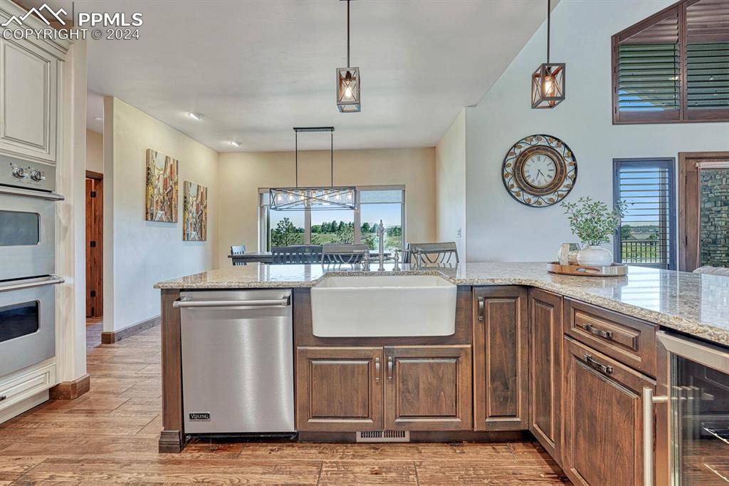 19210 Royal Troon Drive Monument, CO 80132 - Photo 14 of 50 a kitchen with stainless steel appliances granite countertop a stove a sink and a refrigerator