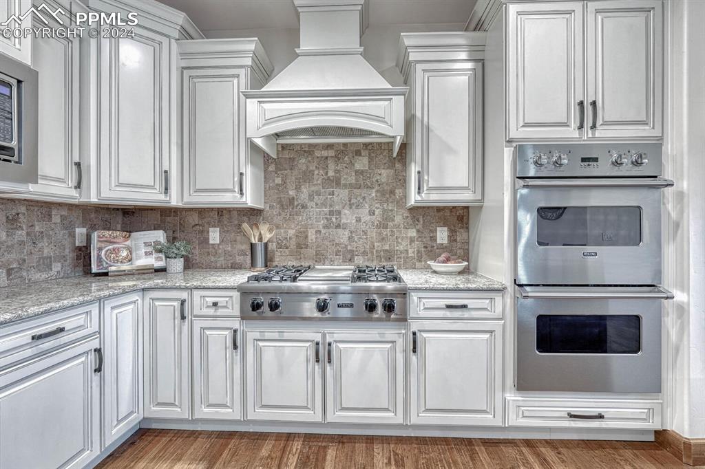 19210 Royal Troon Drive Monument, CO 80132 - Photo 15 of 50 a kitchen with stainless steel appliances granite countertop a stove and white cabinets