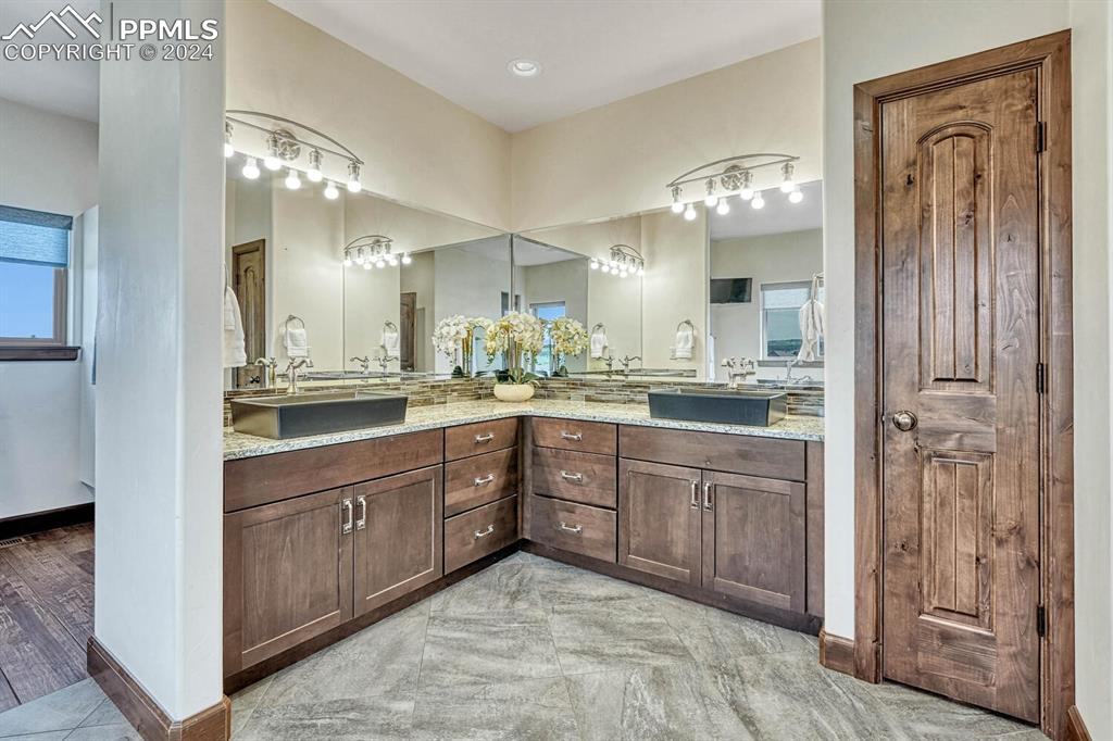 19210 Royal Troon Drive Monument, CO 80132 - Photo 23 of 50 a bathroom with a sink a large mirror and a shower