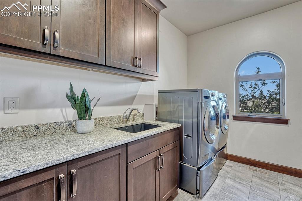 19210 Royal Troon Drive Monument, CO 80132 - Photo 26 of 50 a kitchen with stainless steel appliances granite countertop a sink a stove and a wooden cabinets