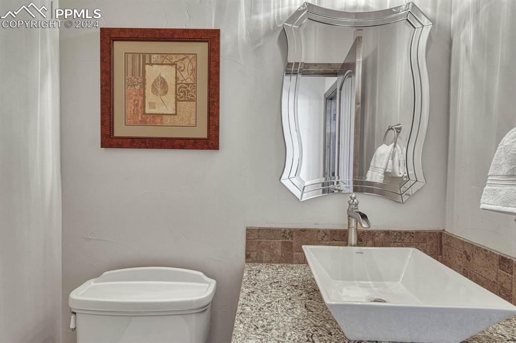 19210 Royal Troon Drive Monument, CO 80132 - Photo 27 of 50 a bathroom with a toilet sink and mirror