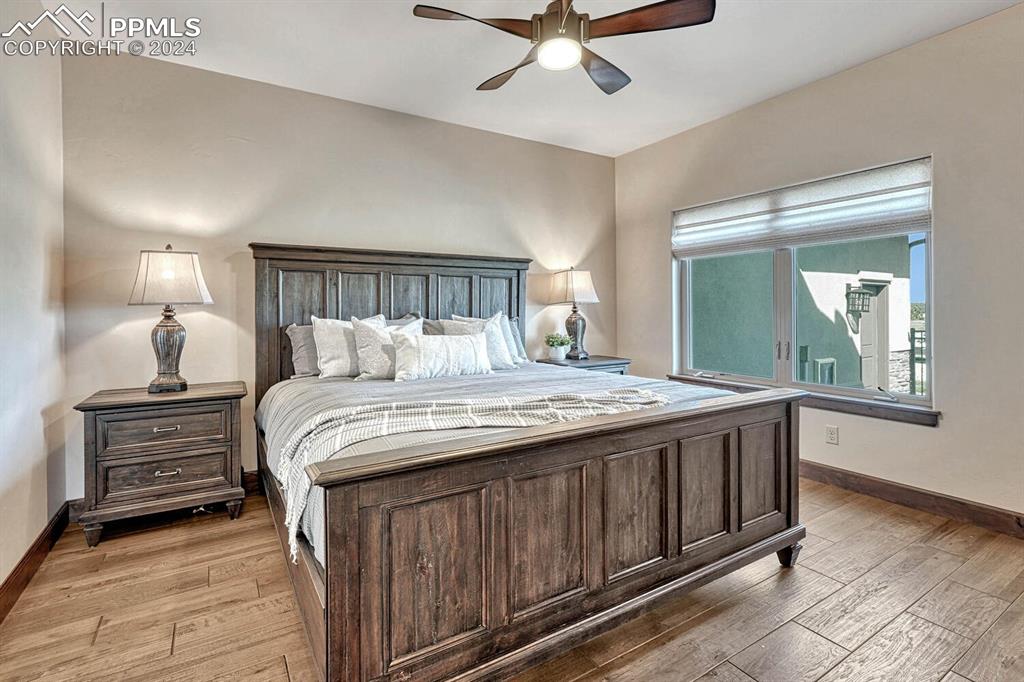 19210 Royal Troon Drive Monument, CO 80132 - Photo 28 of 50 a bedroom with a large bed and a chandelier