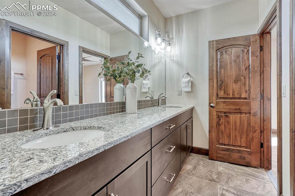 19210 Royal Troon Drive Monument, CO 80132 - Photo 29 of 50 a bathroom with a granite countertop sink and a mirror