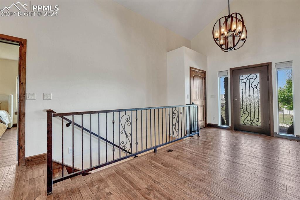 19210 Royal Troon Drive Monument, CO 80132 - Photo 9 of 50 a view of a hallway to wooden floor and a chandelier