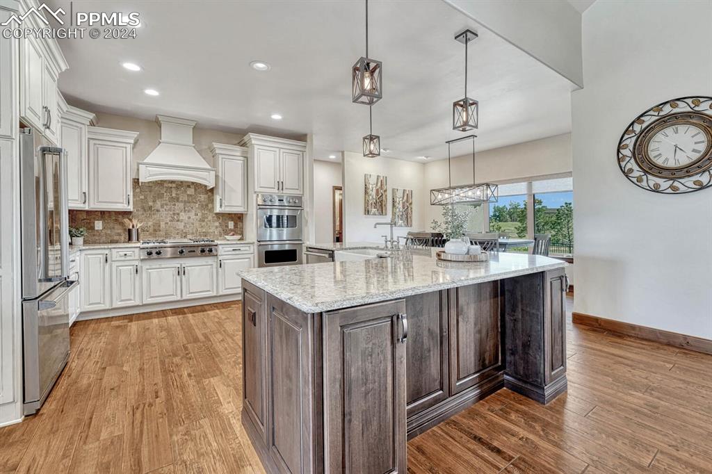 19210 Royal Troon Drive Monument, CO 80132 - Photo 10 of 50 a kitchen with stainless steel appliances granite countertop a sink stove and wooden floor