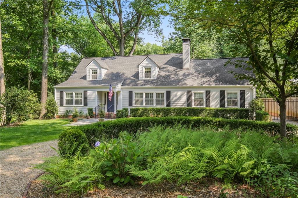 1403 Moores Mill Road Northwest Atlanta, GA 30327 - Photo 2 of 30 a front view of a house with a garden