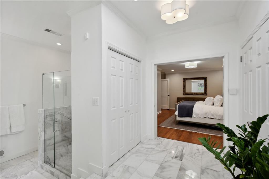 1403 Moores Mill Road Northwest Atlanta, GA 30327 - Photo 21 of 30 a bedroom with a large bed and a chandelier