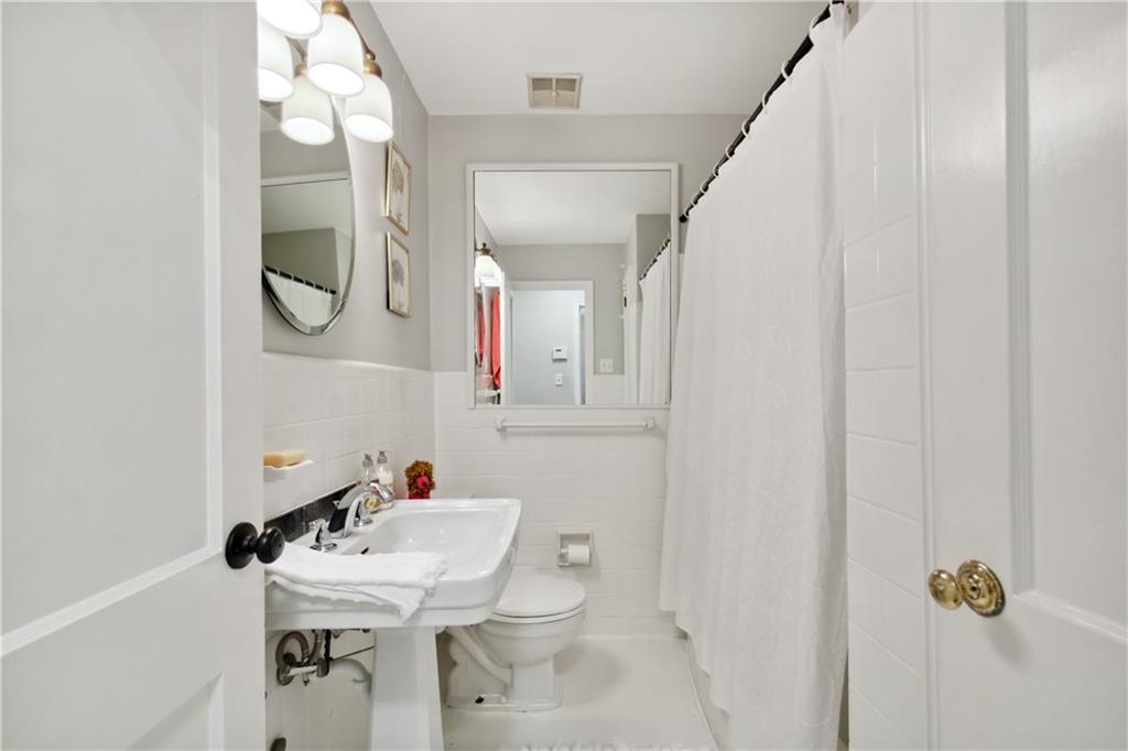 1403 Moores Mill Road Northwest Atlanta, GA 30327 - Photo 24 of 30 a bathroom with a sink vanity mirror and toilet