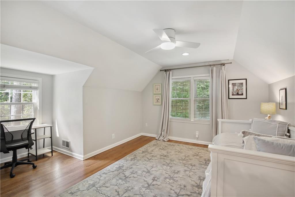 1403 Moores Mill Road Northwest Atlanta, GA 30327 - Photo 25 of 30 a spacious bedroom with a bed a table and potted plant on the counter