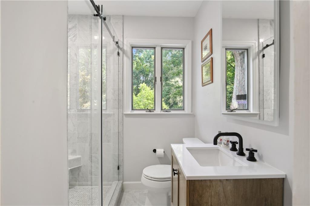 1403 Moores Mill Road Northwest Atlanta, GA 30327 - Photo 26 of 30 a bathroom with a sink a toilet and a window