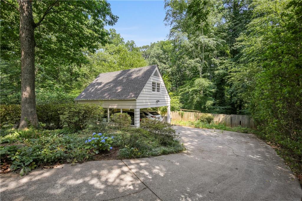 1403 Moores Mill Road Northwest Atlanta, GA 30327 - Photo 29 of 30 a view of a back yard with plants and large trees