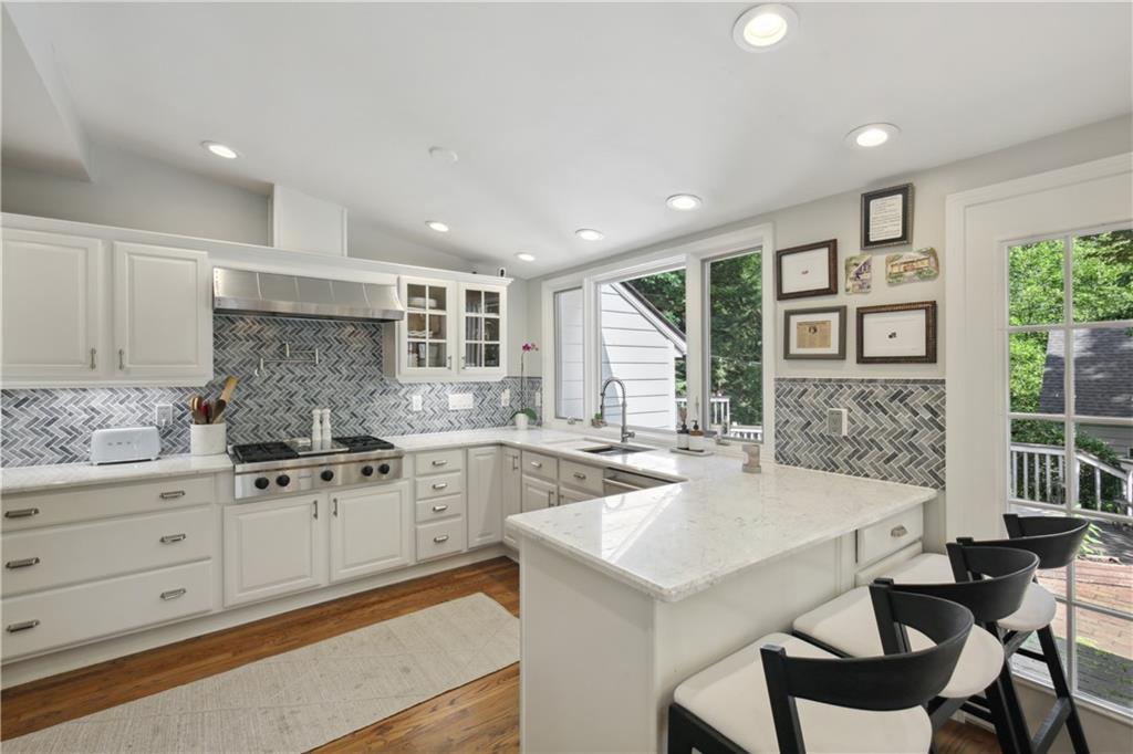 1403 Moores Mill Road Northwest Atlanta, GA 30327 - Photo 10 of 30 a kitchen with granite countertop cabinets a stove a dining table and chairs