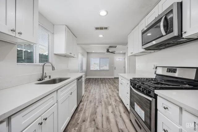 a kitchen with granite countertop a sink stove and cabinets