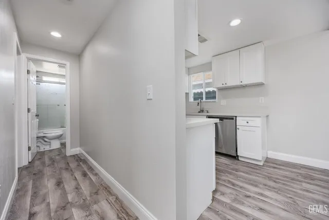 a kitchen with a sink and wooden floor