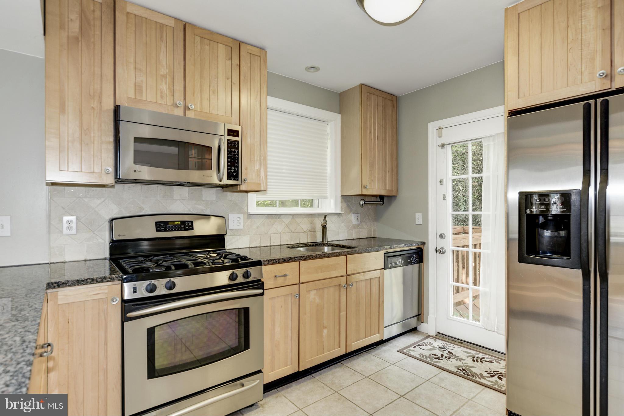 9006 Walden Road Silver Spring, MD 20901 - Photo 13 of 30 a kitchen with granite countertop cabinets stainless steel appliances and a counter space
