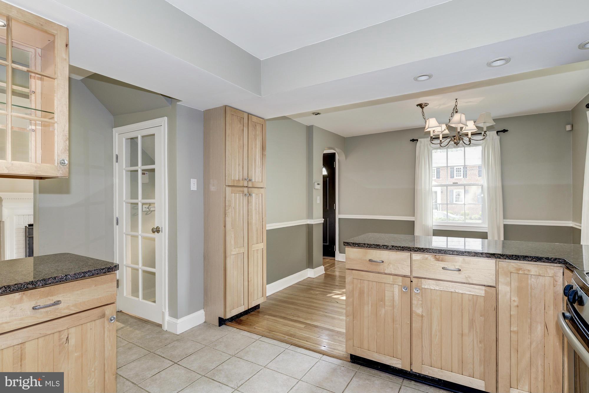 9006 Walden Road Silver Spring, MD 20901 - Photo 14 of 30 a kitchen with white cabinets and chandelier