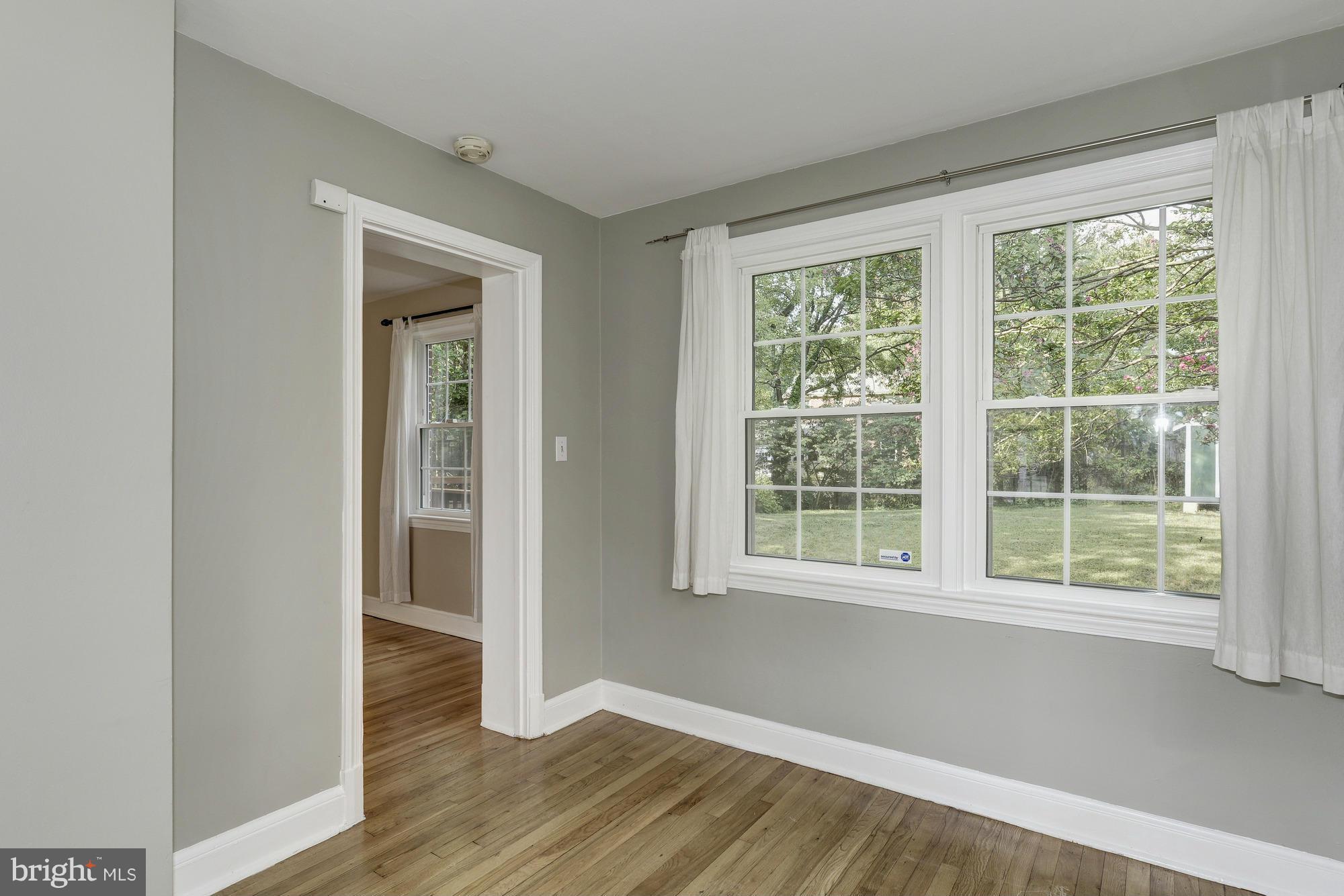 9006 Walden Road Silver Spring, MD 20901 - Photo 9 of 30 a view of an empty room with wooden floor and a window
