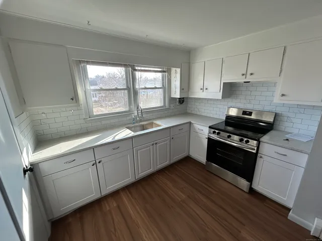 a kitchen with a sink a stove and cabinets