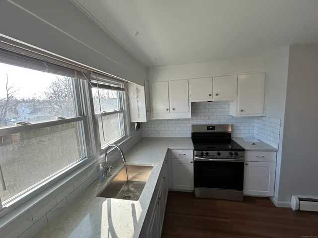 a kitchen with granite countertop a stove and a sink