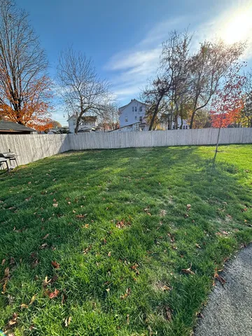 a view of yard with grass and trees
