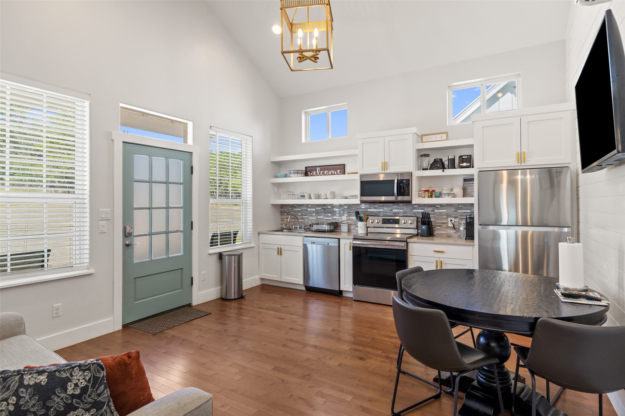 810 Kothmann Road Dripping Springs, TX 78620 - Photo 30 of 40 High vaulted ceilings and rich hardwood flooring frame this open-concept kitchen and dining area.