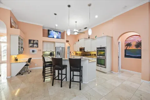 a kitchen with stainless steel appliances kitchen island granite countertop a refrigerator a stove a sink dishwasher with a dining table and chairs