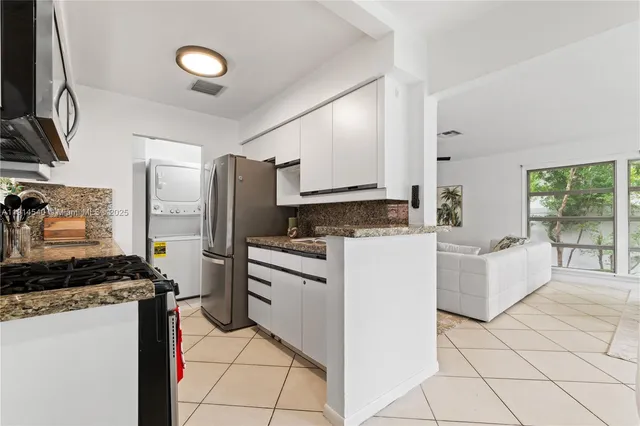 a kitchen with granite countertop a sink stove and refrigerator