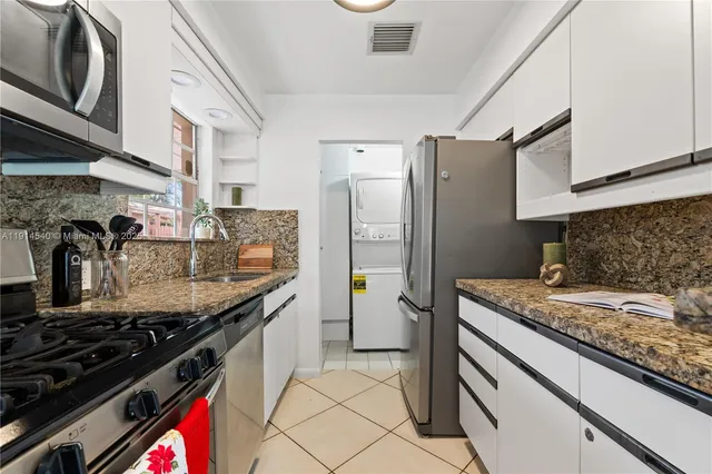 a kitchen with stainless steel appliances granite countertop a sink stove and cabinets
