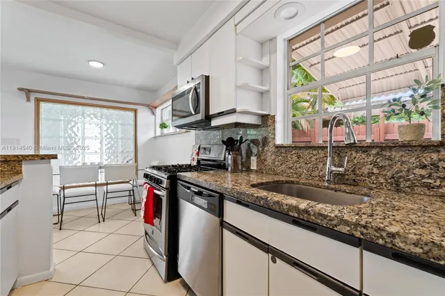a kitchen with stainless steel appliances granite countertop a refrigerator and a sink
