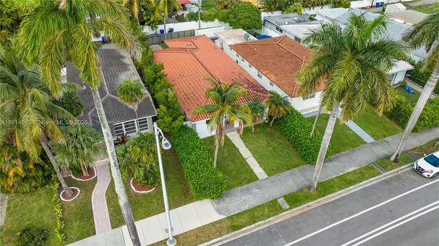 an aerial view of a residential houses with yard