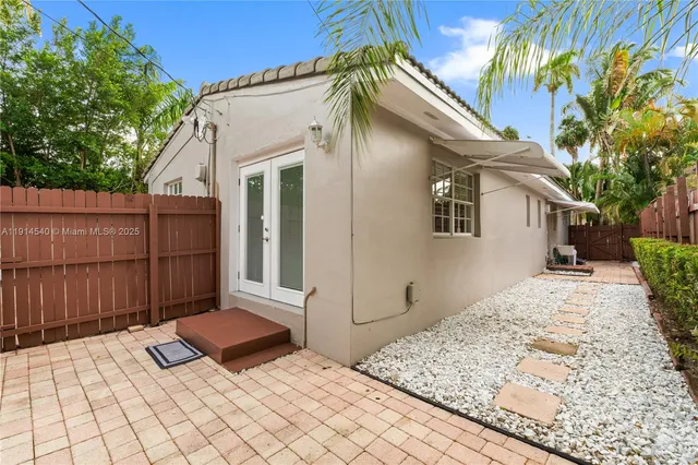 a view of a patio with table and chairs and wooden fence