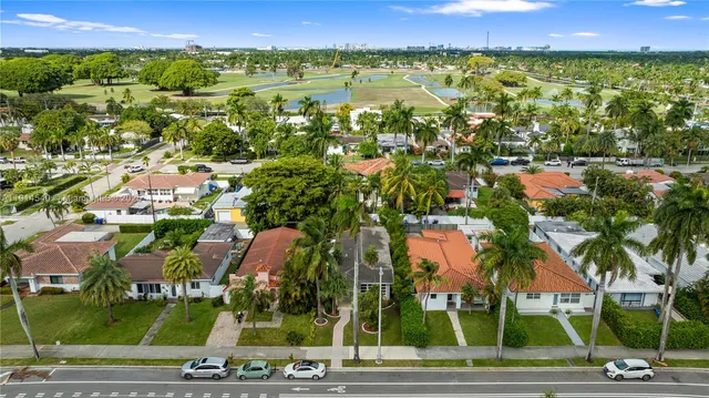 an aerial view of residential houses with outdoor space and trees