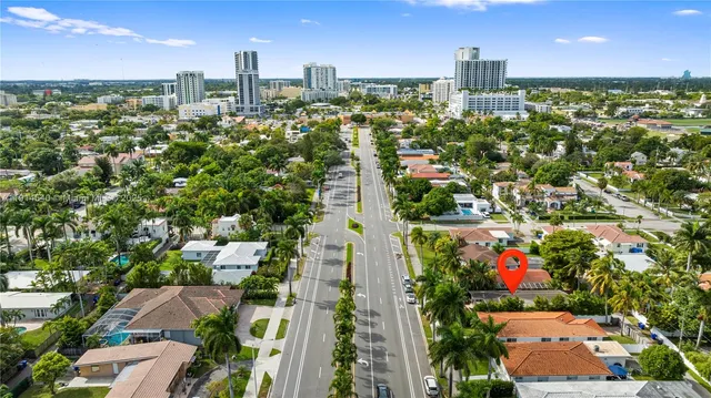 a view of a flower in front of yellow house