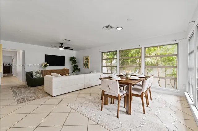 a dining room with furniture and large windows